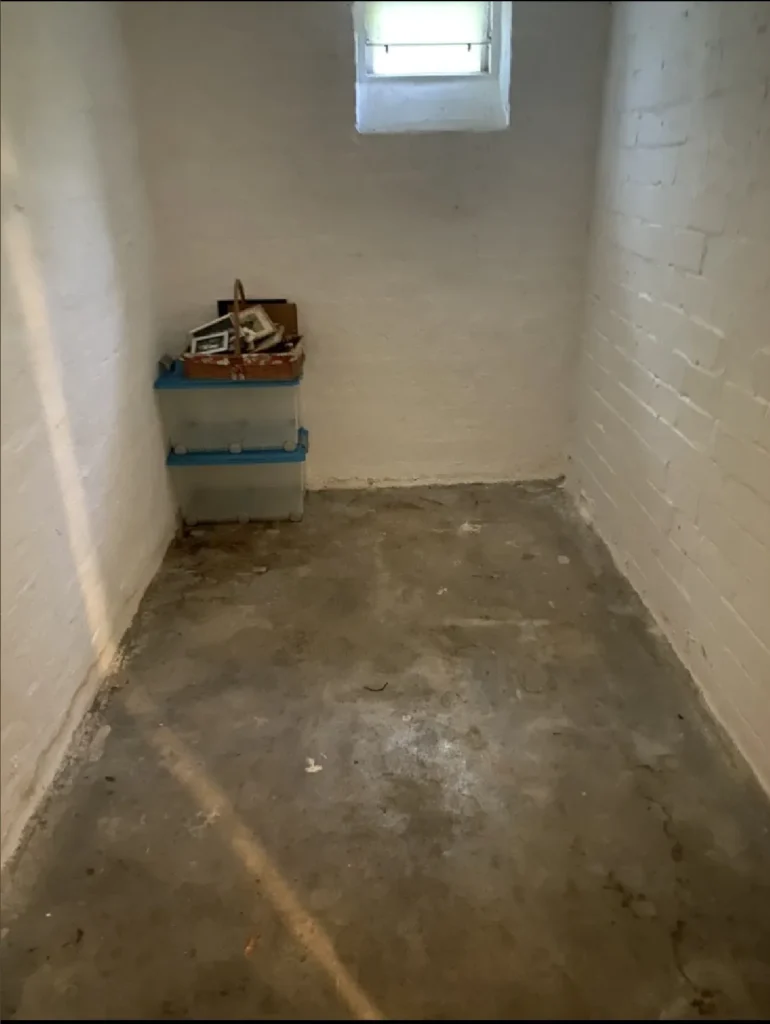 Komplett leeres, sauber gefegtes und bezugsfertiges Wohnzimmer nach der Räumung.