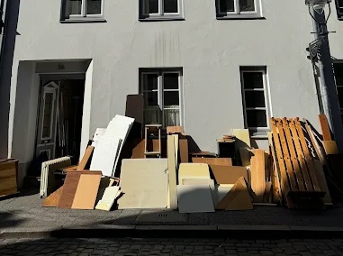 Entsorgung von Altholz und Sperrmüll in großen Recycling-Containern.