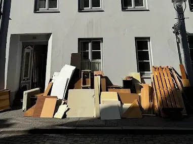 Entsorgung von Altholz und Sperrmüll in großen Recycling-Containern.